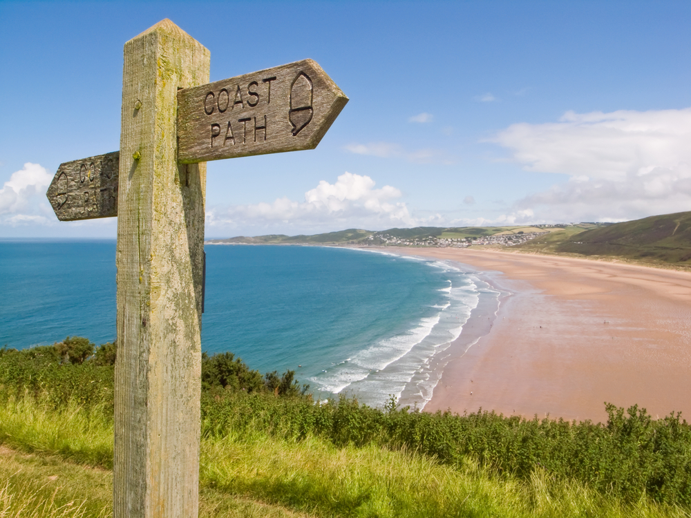 Coastal path with a sign, alongside Woolacombe beach in Devon, England.