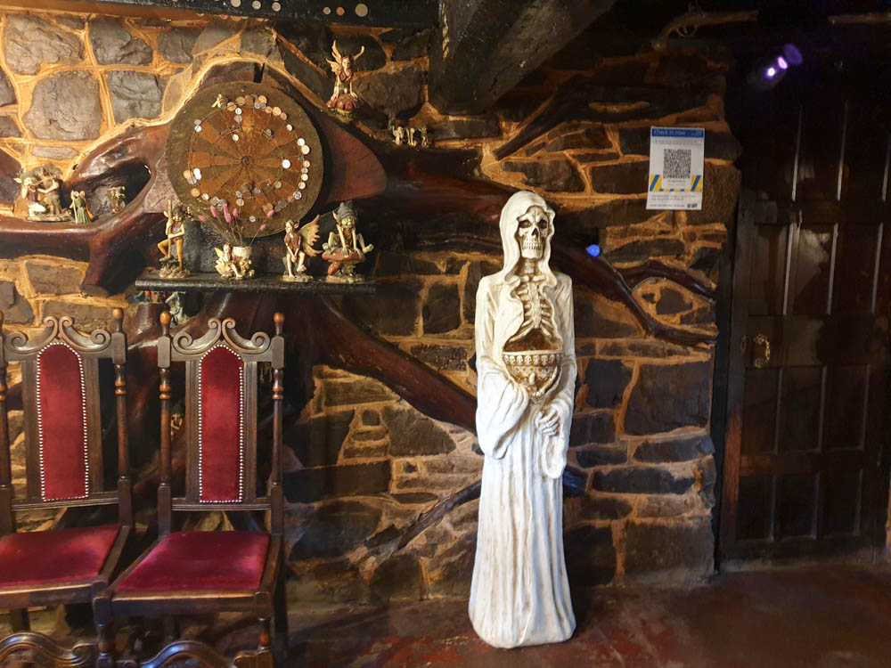 Creepy attractions at Highwayman Inn, with fancy chairs and a skeleton wearing a bridal dress and bare brick in the background