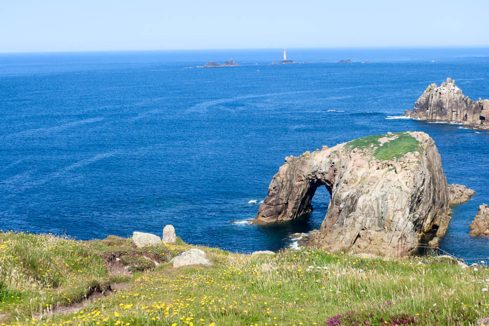An arch going out over the blue sea near Land's End.