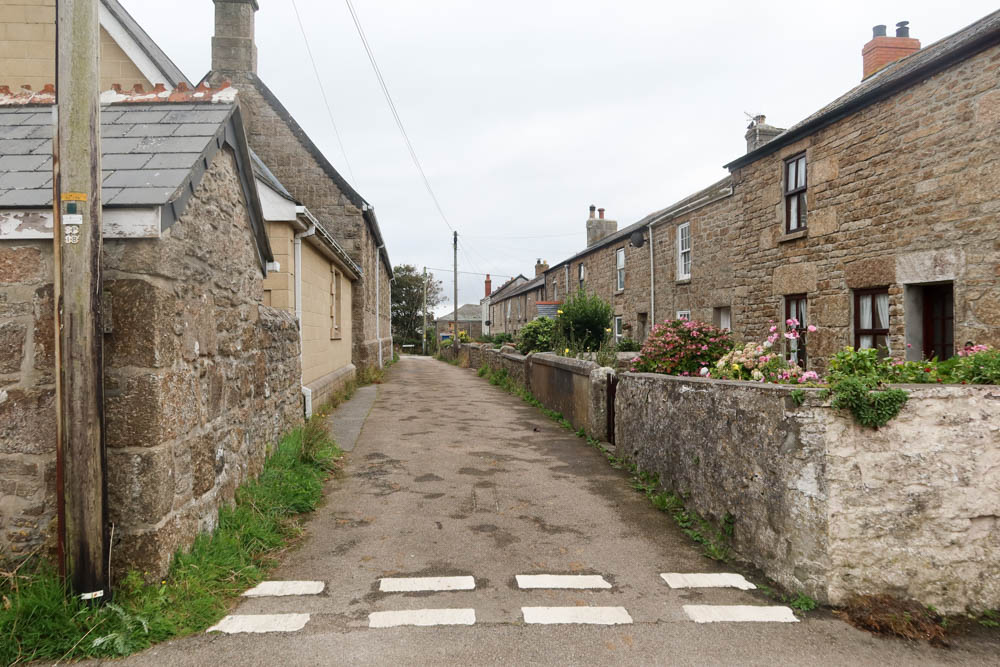 A road lined either side by traditional granite cottages in St Just, Cornwall