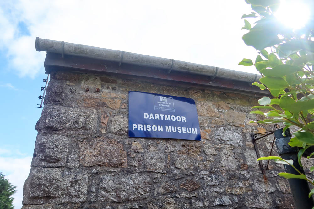 The blue sign of the Dartmoor Prison Musem, it's on the wall of the prison itself