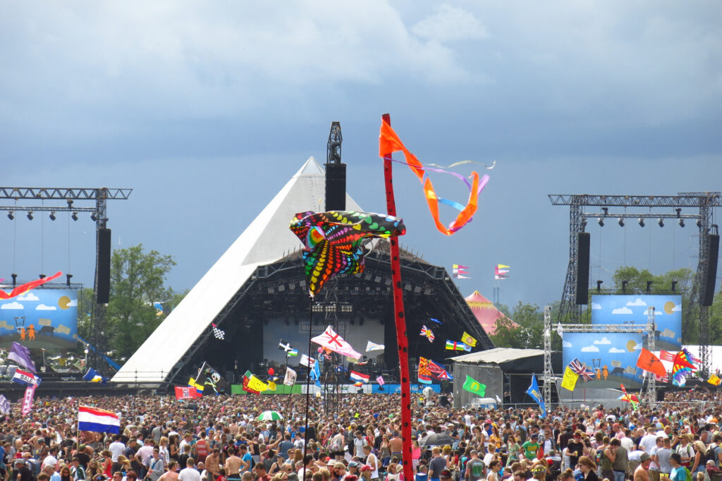 Glastonbury, United Kingdom - June 27, 2014: Stormy skies can't keep the crowds away from the Pyramid Stage at Glastonbury Festival in Somerset, England.