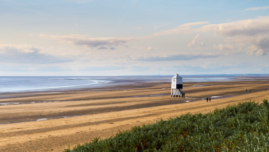 Wooden lighthouse from 1932 standing tall on stilts at a Somerset beach