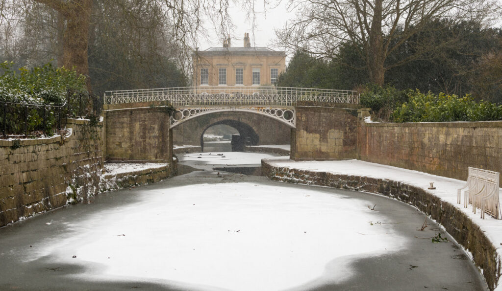 Iced formed on surface of waterway by Sydney Gardens, running through centre of World Heritage City in Somerset, UK