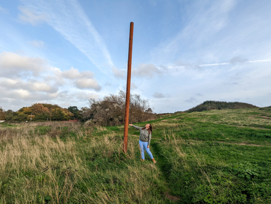 Girl standing next to rusty pole in the Maer grassland in Exmouth