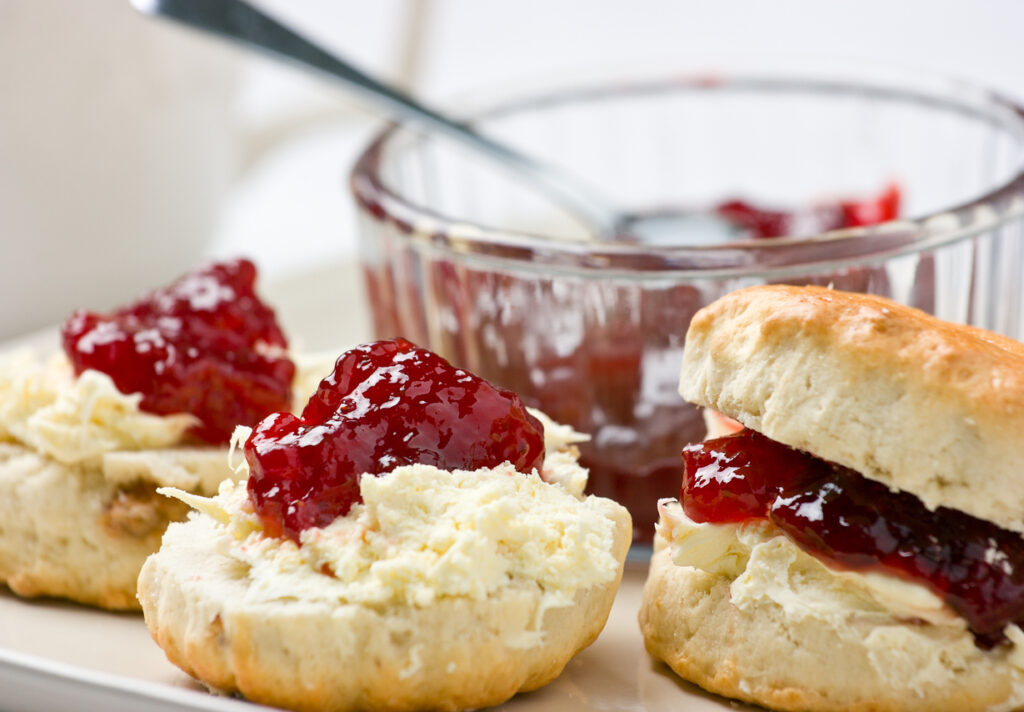 Home-baked scones tea with strawberry jam and clotted cream. Shallow depth of field.For similar photos please check out my