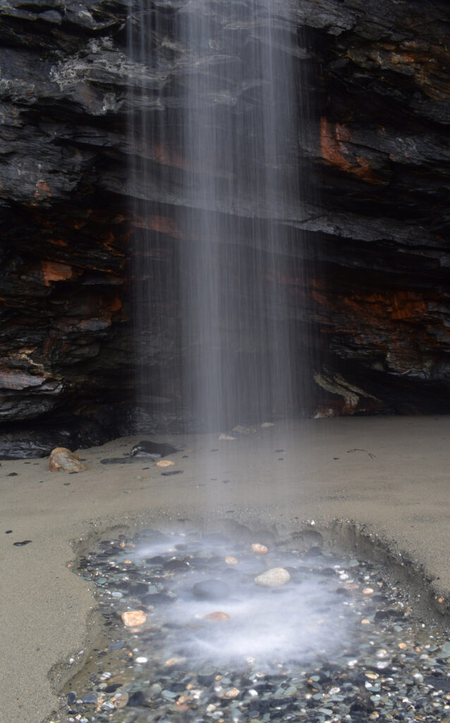 A thin waterfall at Tregardock Beach in Cornwall