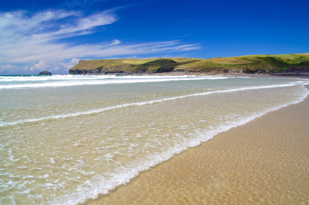 Waves breaking on a beautiful sunny summer day on Polzeath beach, favourite of poet Sir John Betjeman, in Cornwall.