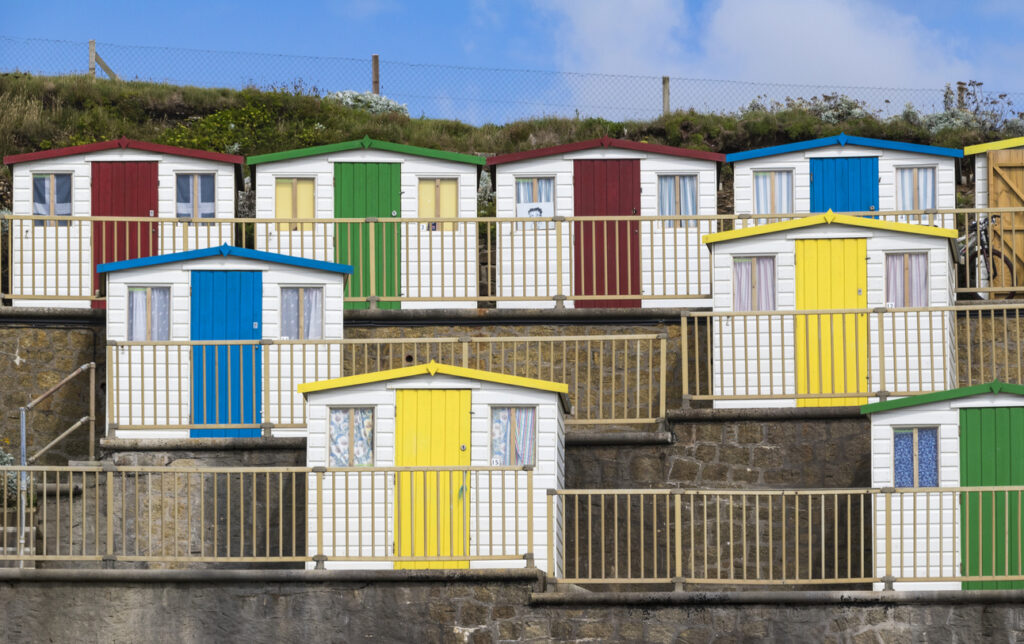 Summerleaze Beach is one of Bude's popular beaches. These brightly coloured beach huts overlook the sheltered tidal sea pool and the Atlantic Ocean. The salt water pool is a safe place for children and the beach is a favourite place for surfers.