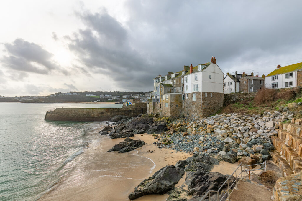 Exposed cottages by the sea on Bamaluz beach, in the fishing harbour of St Ives, in north Cornwall.
