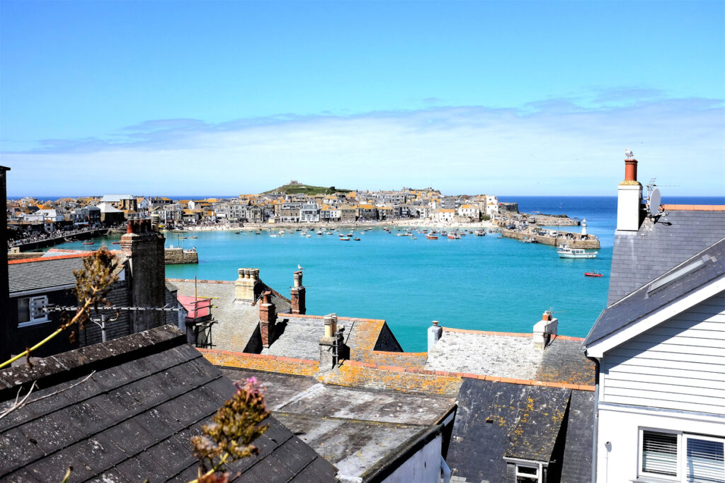 St. Ives, Cornwall, UK. June 30, 2019. The seaside town and harbor taken over the rooftops at St. Ives in Cornwall, UK.