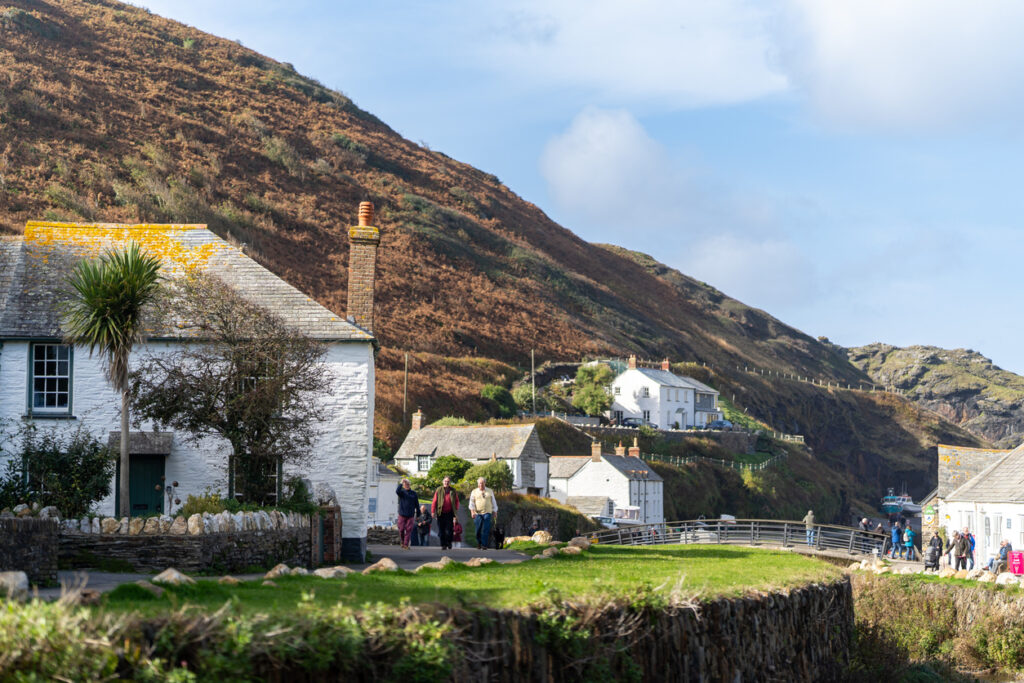 10/23/2021 - The beautiful Cornwall town of Boscastle with old white cottages and river running down to harbour. Sunny day surrounded by rural countryside.