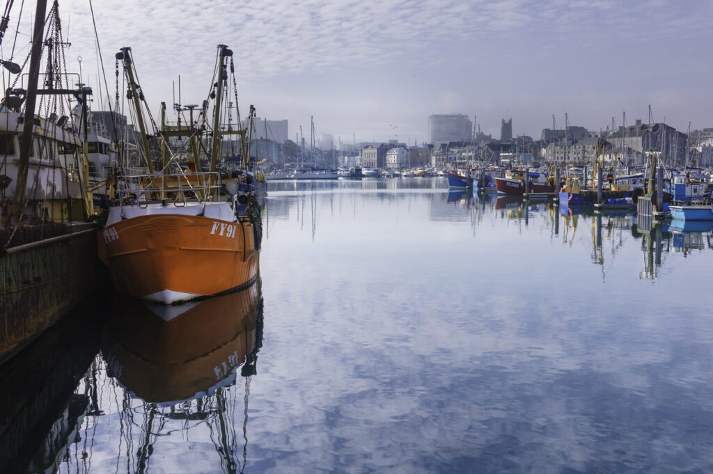 Plymouth, UK - March 02, 2012: Fishing trawlers and small sail boats anchored and moored in the marina at the Barbican Centre on a cold but fine winter's morning in Plymouth, Dorset, UK.