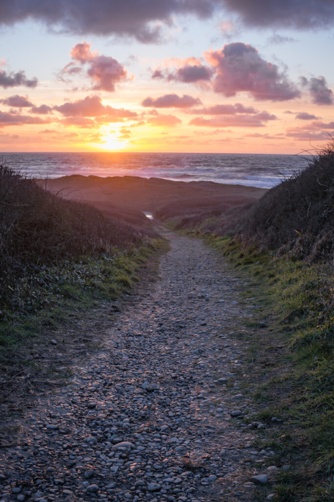 Gravel footpath leading down to the sandy beach of Widemouth Bay, Cornwall.