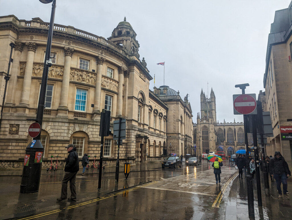Shot of the rainy streets of Bath with historic buildings on either side