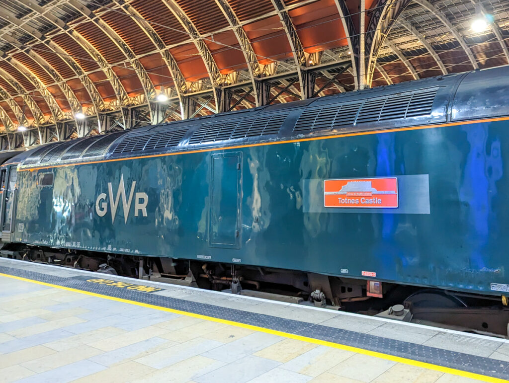 Checking in to the GWR sleeper train, which has emblems of Cornwall on the side.
