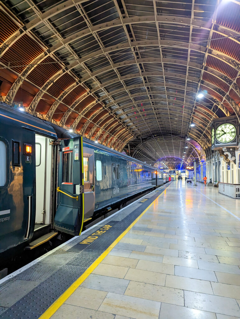 Shot of the platform at London Paddington station, with the green train lining the platform and the domes above the station.