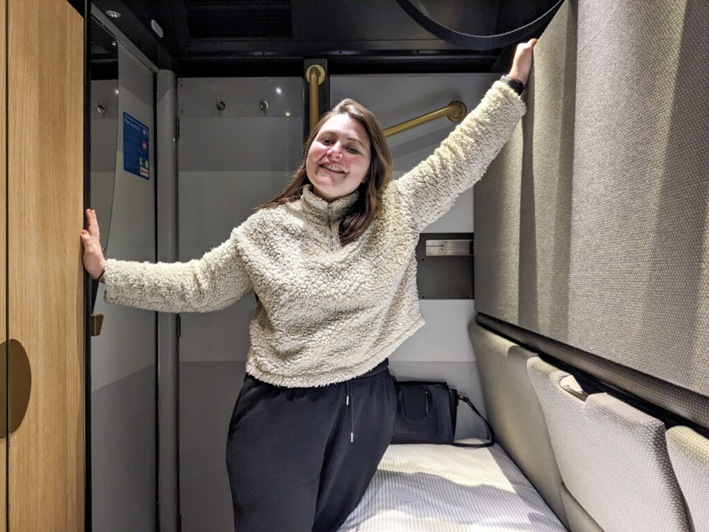 Girl in the cabin on the sleeper train to Cornwall, wearing a cream fleece jumper and tracksuit bottoms