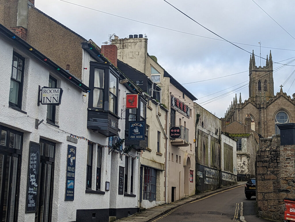 A view up the road of Quay Street in Penzance, with a church at the top.