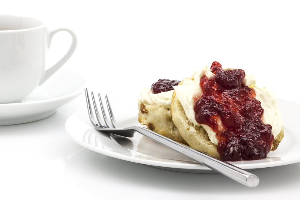 Home-baked scones with strawberry jam and clotted cream, often served with a cup of tea. Known as a cream tea.