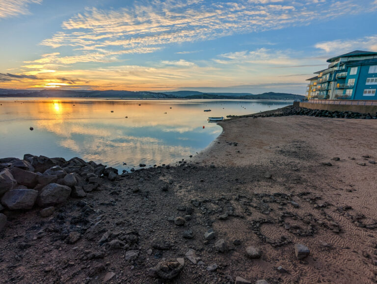 Stunning sunset over a small beach in Exmouth with the colourful marina in the background