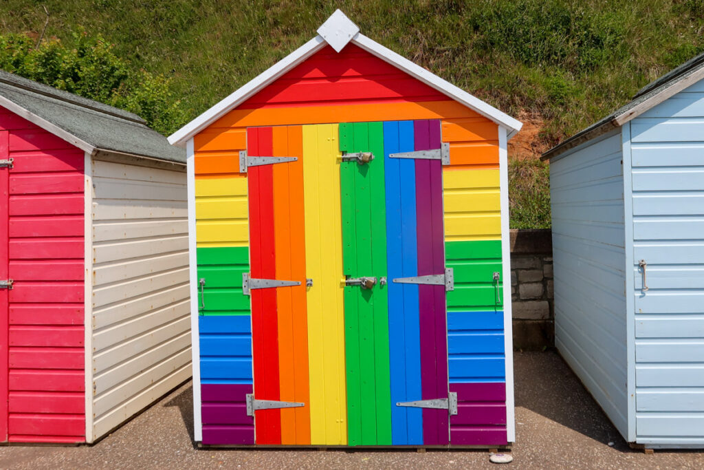 Bright rainbow coloured beach hut.