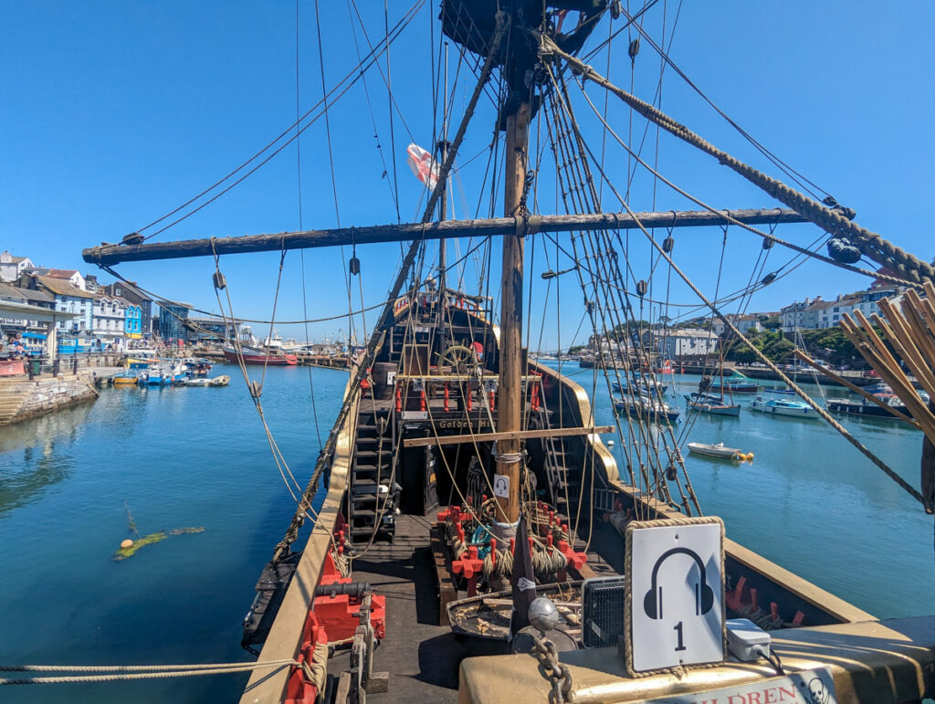The back of Golden Hind Museum Ship against the blue water, in Brixham.