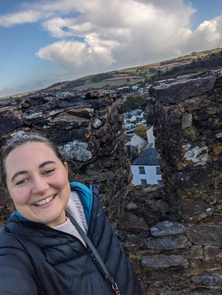Top of Totnes castle, Claire is smiling in the selfie with Totnes below her