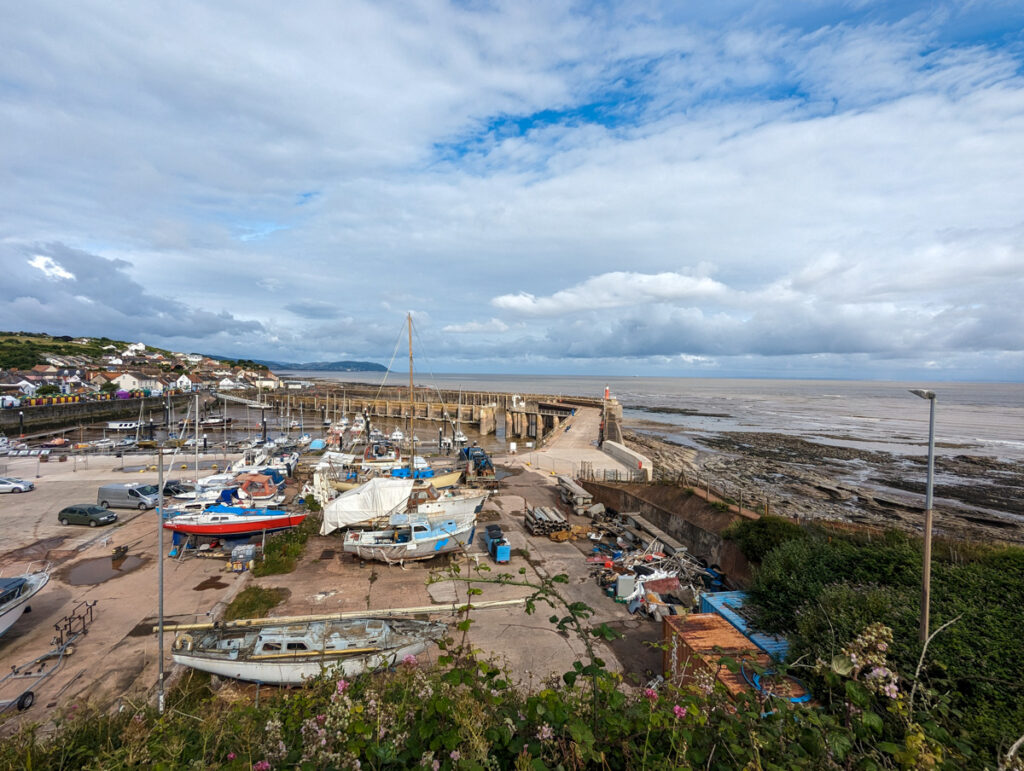 Watchet Harbour in Somerset, with boats on the sand and the sea in the distance. 
