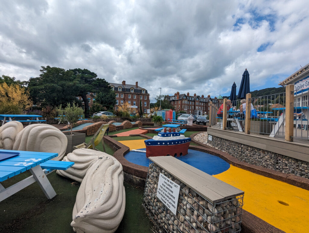 Jubilee Cafe crazy golf in Minehead, with a cloudy sky in the background.